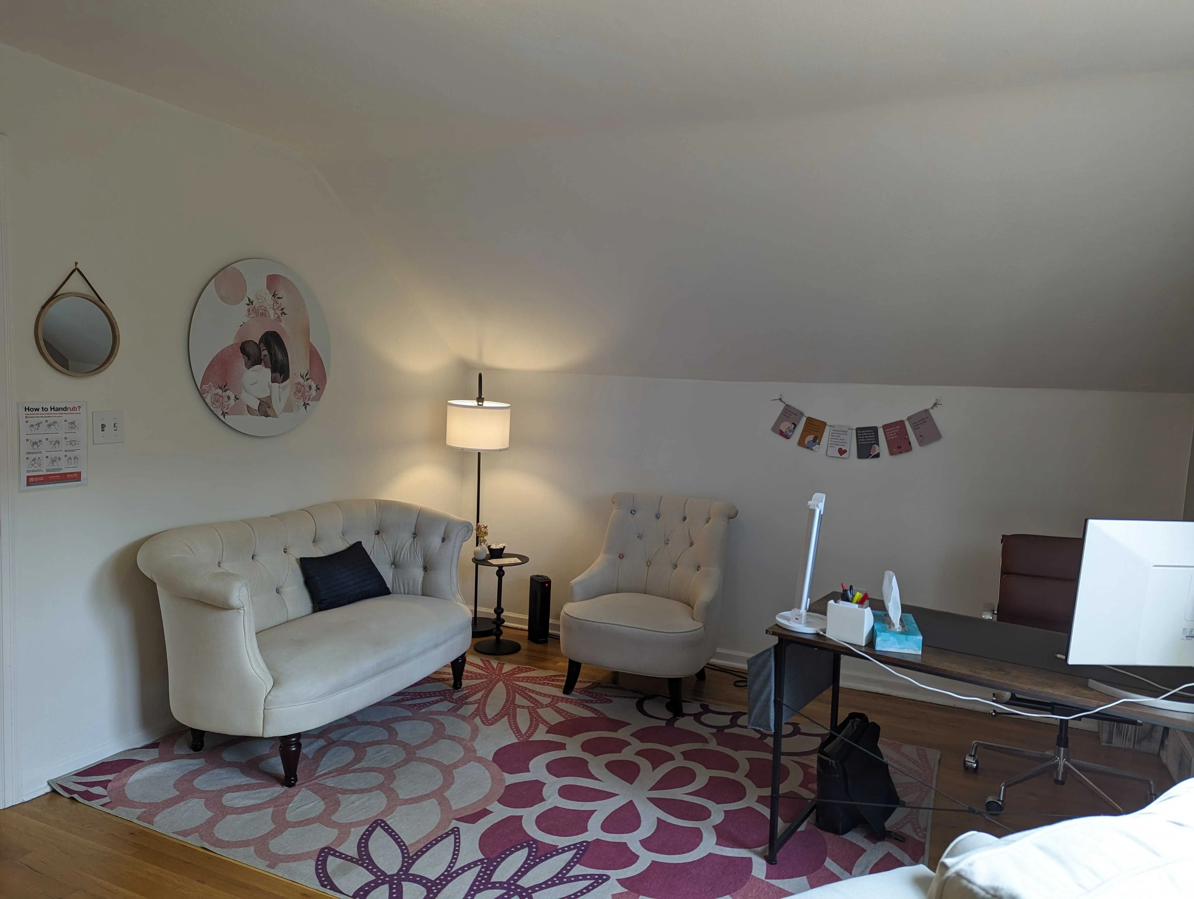 An upstairs room with a cream sofa, two armchairs, a desk and a patterned rug