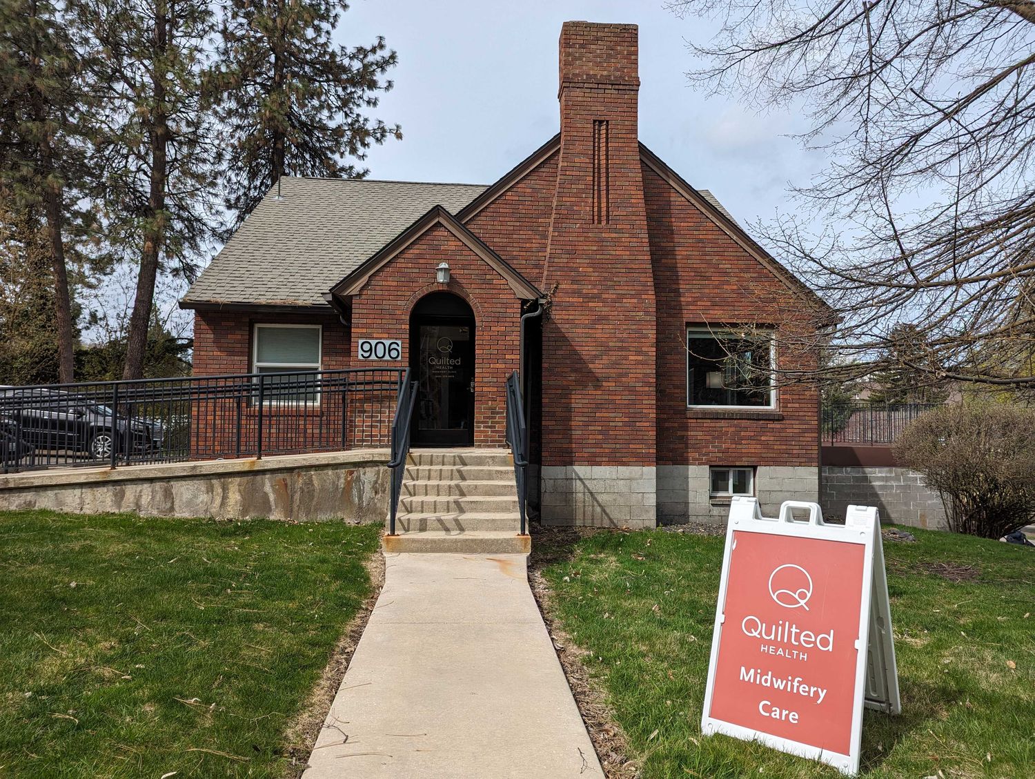 The Quilted Midwives clinic at 906 South Cowley Street — a brick house with a path to the front door