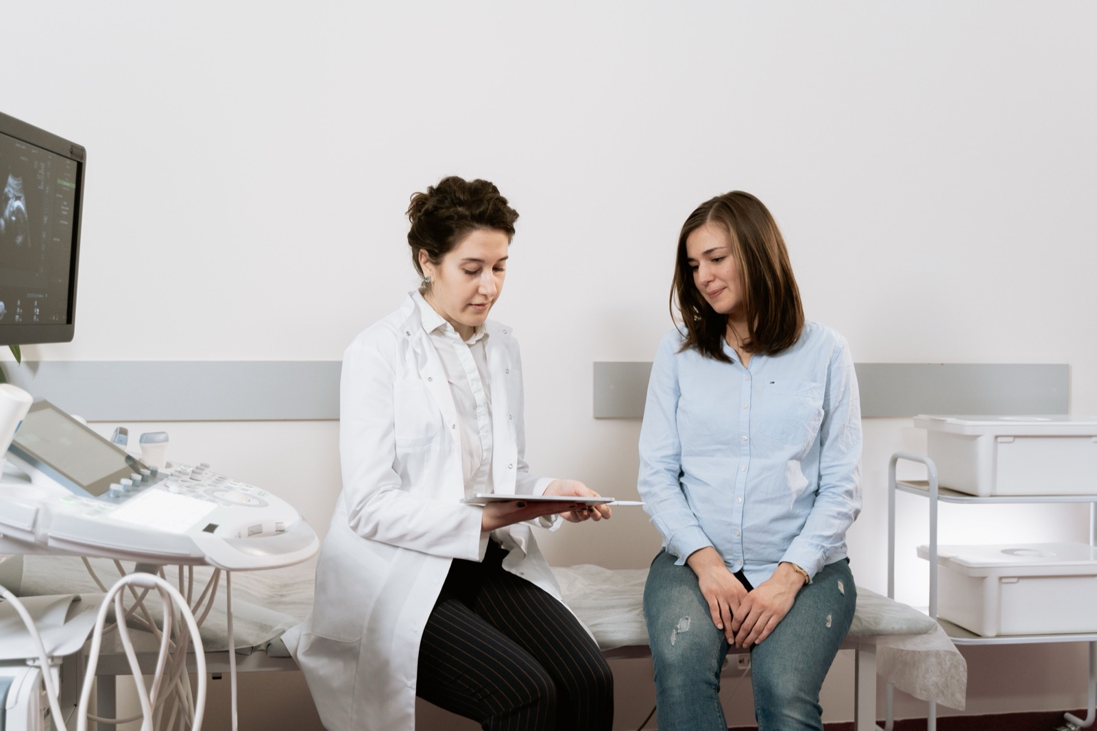 A midwife going through results with a client in a clinic room