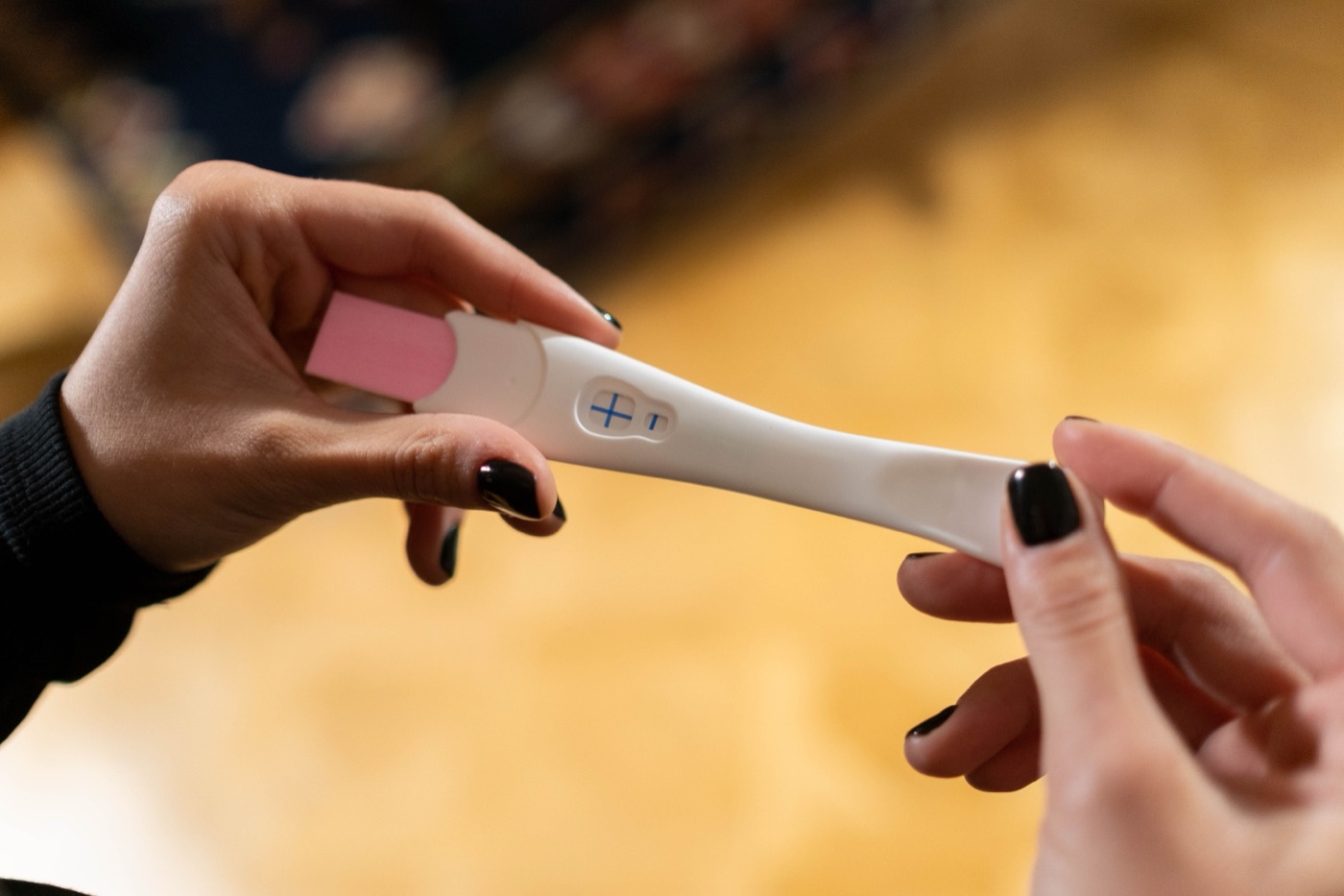 Two people looking at a positive pregnancy test together