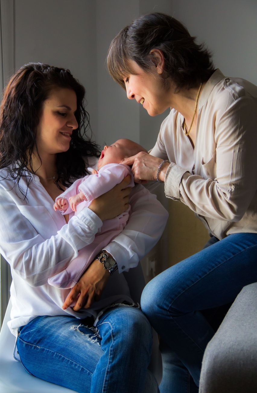 A midwife with a mother and her newborn