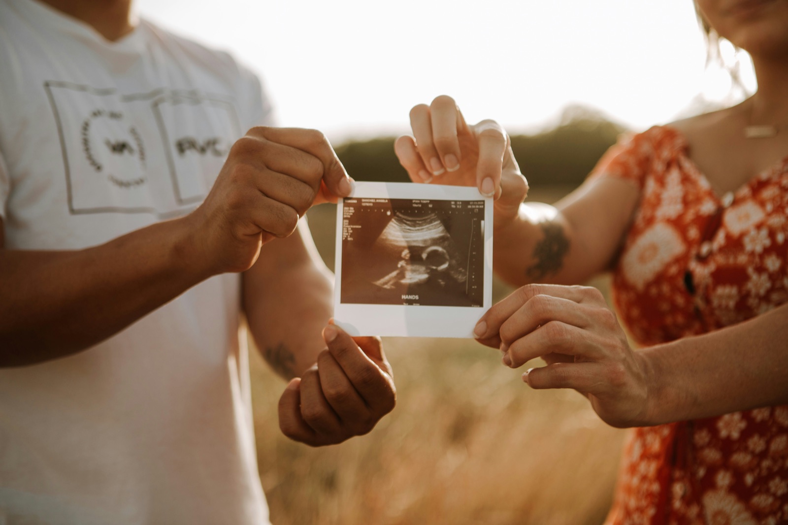 Two expectant parents holding up an ultrasound photograph