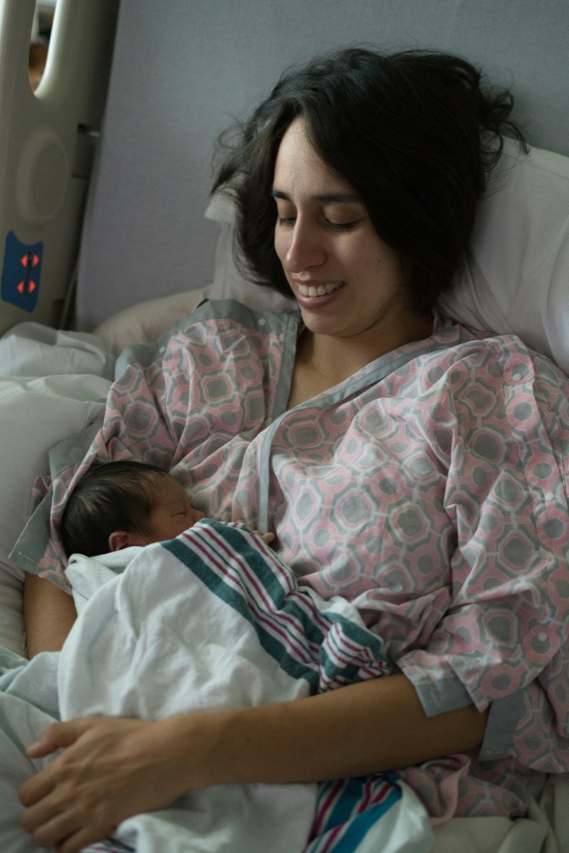 A parent resting with their newborn after the birth